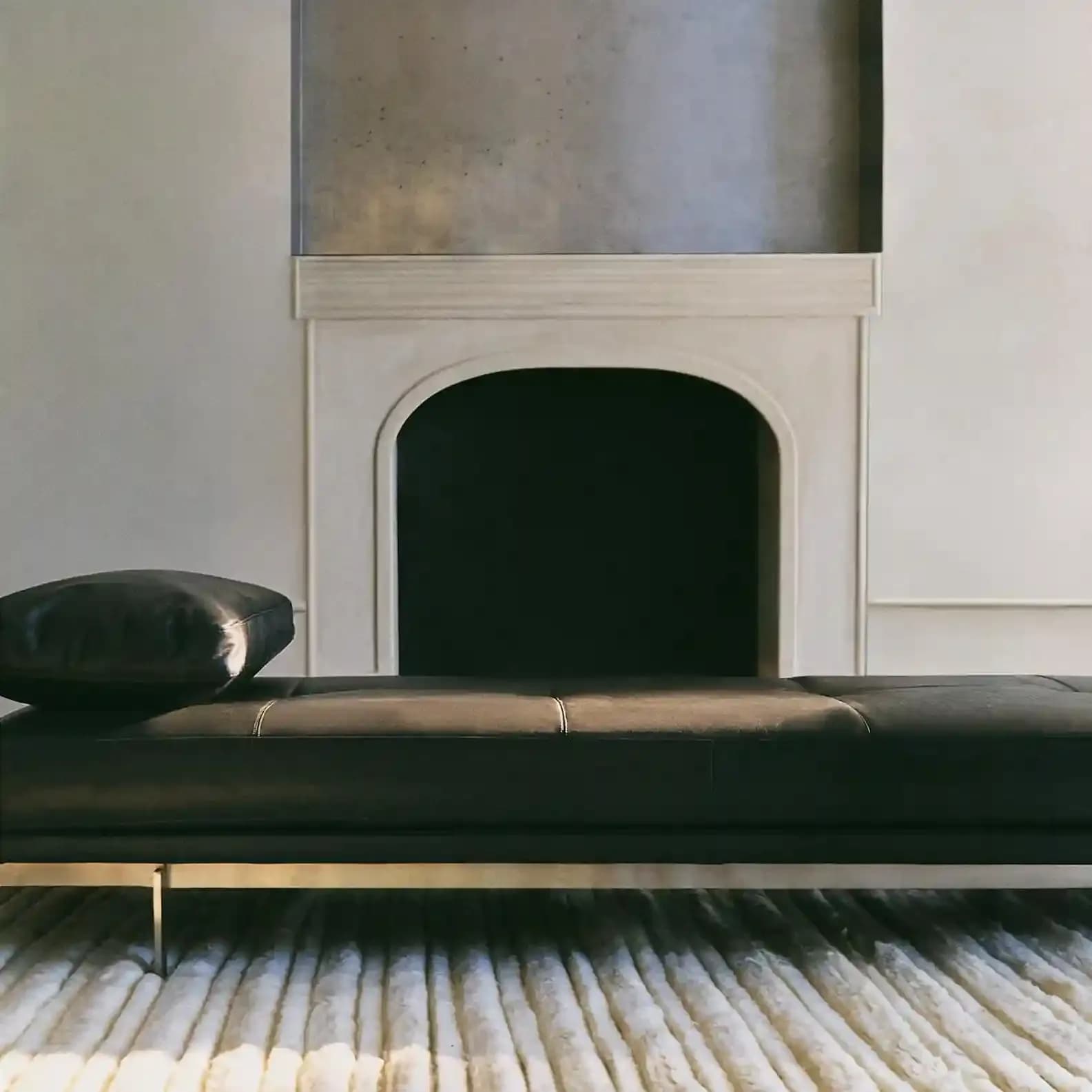 Un intérieur minimaliste avec une banquette en cuir noir et des textures douces, reflétant des matériaux raffinés, des lignes épurées et une esthétique contemporaine en phase avec les environnements de la mode actuelle.